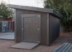 a small metal outhouse sitting in the dirt