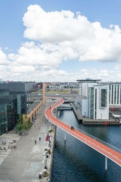 an aerial view of a bridge over a body of water with buildings in the background