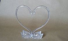 a clear glass heart shaped object sitting on top of a table