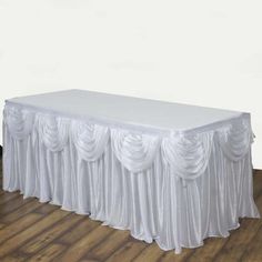 a white table cloth draped over it on top of a wooden floor