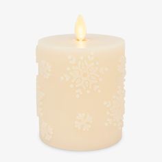 a lit candle with snowflakes on it