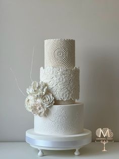 a three tiered white wedding cake with flowers on top