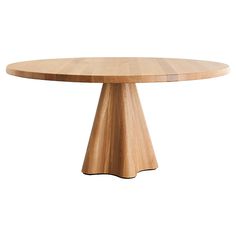 a round wooden table sitting on top of a white floor