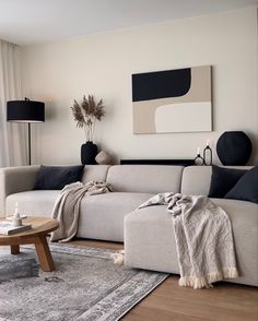 a living room with a couch, coffee table and rugs on the hardwood floor