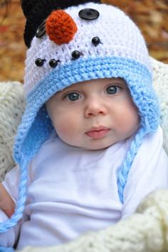 a baby wearing a crocheted snowman hat