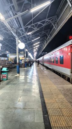 a red and white train parked at a train station