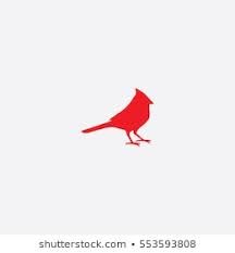 a red bird sitting on top of a white wall