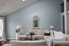 a living room with blue walls and white furniture