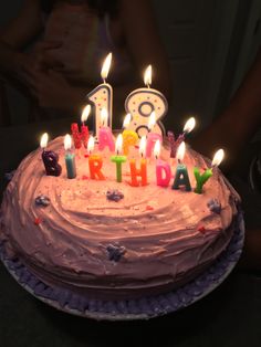 a birthday cake with lit candles on it