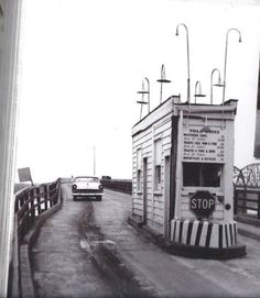 an old black and white photo of a stop sign on the side of a road