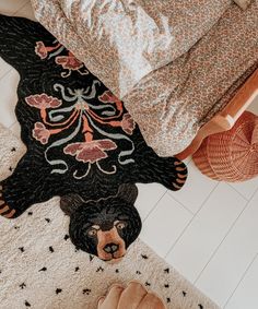 a bear rug is on the floor next to a bed and pillows, with a person's feet in the foreground