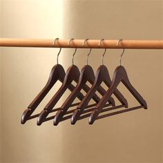 four wooden clothes hangers hanging on a rail