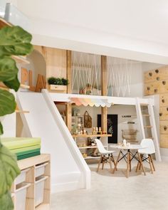 a living room filled with white furniture and lots of green leaves on the wall next to it