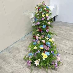 there is a very tall flower arrangement on the floor