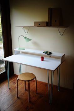 a white desk with two green hairpinks on it