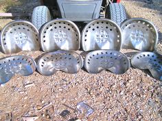 several pieces of metal sitting on the ground next to each other in front of a vehicle