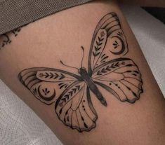 a black and white butterfly tattoo on the leg