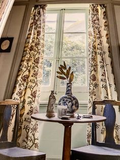 two chairs and a table in front of a window