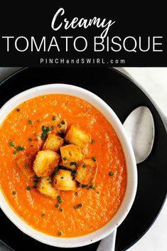 a bowl of creamy tomato bisque with croutons