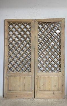 two wooden doors with lattice designs on them