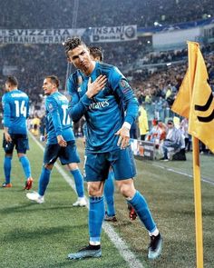 two soccer players are standing on the field with their arms around each other and one is covering his face