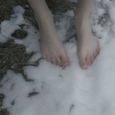 a person standing in the snow with their bare feet