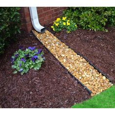 a garden path made out of wood chips and mulch next to a flower bed