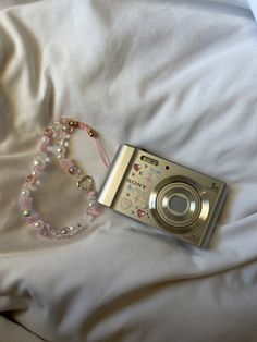 a camera and some beads on a bed