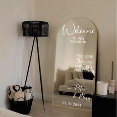 a welcome sign in front of a mirror with a basket on the floor next to it