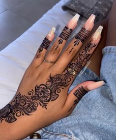 a woman's hand with henna tattoos on it