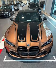 an orange and black bmw sports car in a showroom with other cars behind it