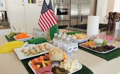 a table filled with assorted food items and an american flag on the wall behind it