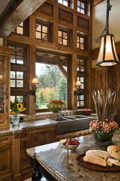 a kitchen filled with lots of wooden cabinets and counter top space next to a window