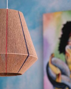 a wooden lamp hanging from a ceiling next to paintings