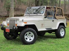 a jeep parked in the grass near trees