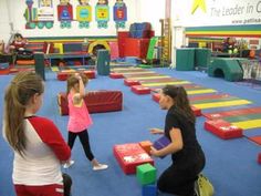 two girls are playing with blocks in a gym