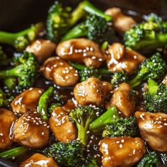 chicken and broccoli stir fry in a wok with sesame seeds on top