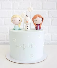 a cake with three figurines sitting on top of it