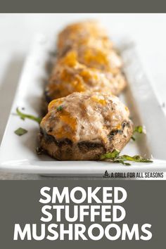 two stuffed mushrooms on a white plate with the words smoked stuffed mushrooms above it and below