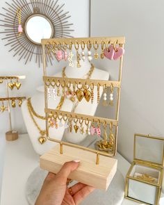 a person is holding up a jewelry stand