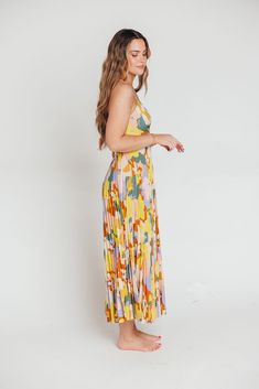 The Blythe Maxi Dress is giving sunshine and ocean breezes, and she's sure to be one of the most colorful pieces in your closet! This stunning maxi dress features a plunging neckline and voluminous skirt, and its abstract floral pattern will give you a gorgeous glow. Imagine wearing this beauty on a beach vacation, at a summer wedding, or on a special date night; you'll be the star of the show wherever you go! FIT: Runs true to size; bodice runs fitted. MODEL: Model is 5’7” / wearing a small. MATERIAL: Self: 100% Polyester; Lining: 100% Polyester. Dry clean only. GARMENT DETAILS: Lightweight sleeveless maxi dress with plisse details. Fitted bodice features a plunging V-neckline, with adjustable straps that crisscross in the back; back is finished with a cut-out detail and tie. Skirt is ver Summer Brunch Flowy Maxi Dress, Summer Brunch Maxi Dress With Flowy Skirt, Summer Maxi Dress For Brunch With Flowy Skirt, Flowy Maxi Dress For Summer Brunch, Breezy Multicolor Maxi Dress For Beach Season, Beach Season Floor-length Maxi Dress For Brunch, Summer Midi Dress For Brunch, Floor-length, Summer Floor-length Midi Dress For Brunch, Vibrant Dresses For Summer Parties In Spring