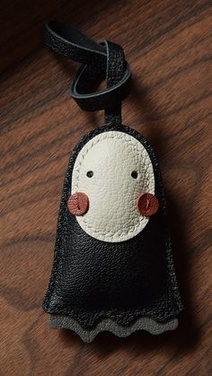 a black and white bag with a red nose on top of a wooden table next to a cell phone