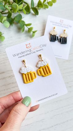 a pair of beer earrings sitting on top of a card