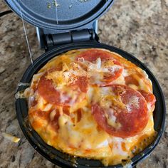 a pizza sitting on top of a pan covered in cheese and pepperoni