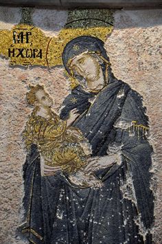 an image of the virgin mary holding a child in her arms, painted on a wall