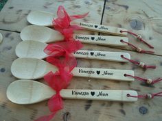 six wooden spoons with names on them and red ribbon tied around the spoons