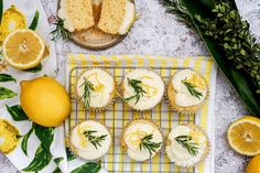 lemon cupcakes with white frosting and fresh herbs