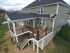 an aerial view of a two story house with deck and stairs leading up to the second floor