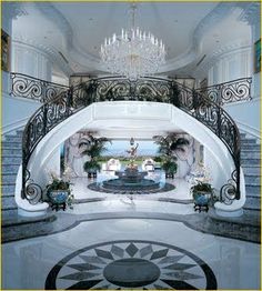 an ornate staircase with chandelier and marble floors