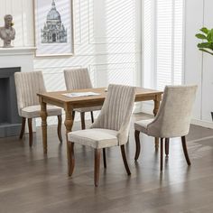 a dining room table and chairs in front of a fire place with a potted plant